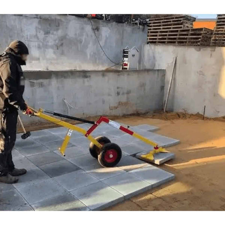 Sollevatore Ravendo TLT 125 giallo e rosso utilizzato per spostare una lastra durante la posa della pavimentazione.